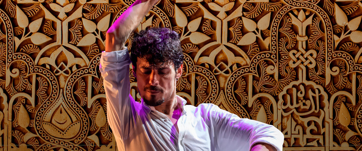 Ímagen de Jesús Carmona bailando sobre un fondo de madera con motivos arabes